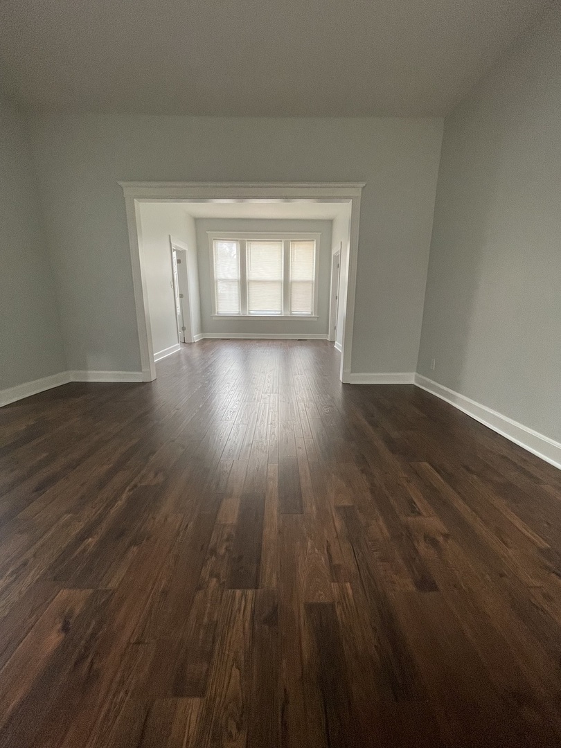 916 West 68th Street, Unit 1W Chicago, IL 60621 - Photo 3 of 8 a view of wooden floor and windows in a room