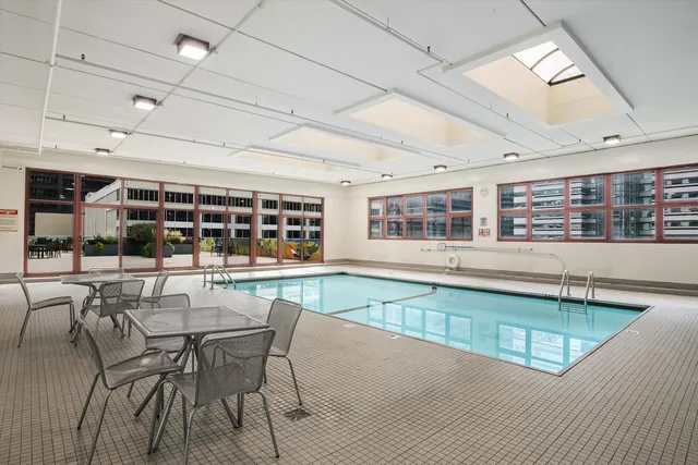 a dining hall with stainless steel appliances granite countertop a stove and a dining table with the kitchen view