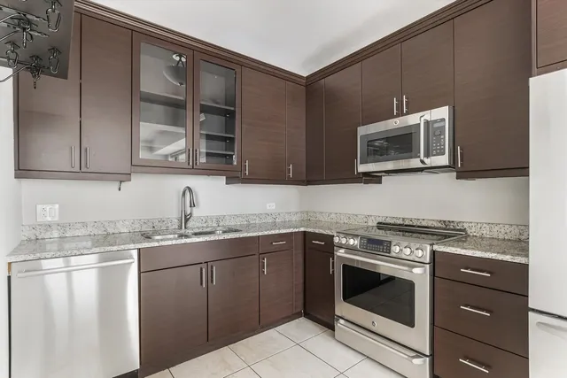 a kitchen with stainless steel appliances granite countertop a stove microwave and cabinets