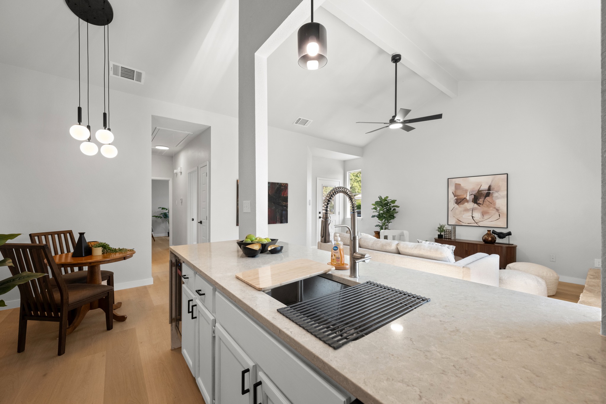 6501 Brush Country Road, Unit 120 Austin, TX 78749 - Photo 9 of 26 Open-concept kitchen and living area featuring light wood-finish flooring, modern lighting fixtures and a gorgeous light ash ceramic tile