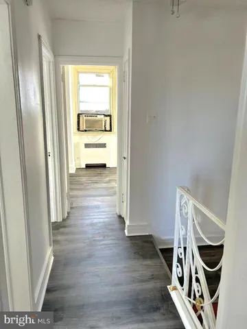 a view of a hallway with wooden floor and closet