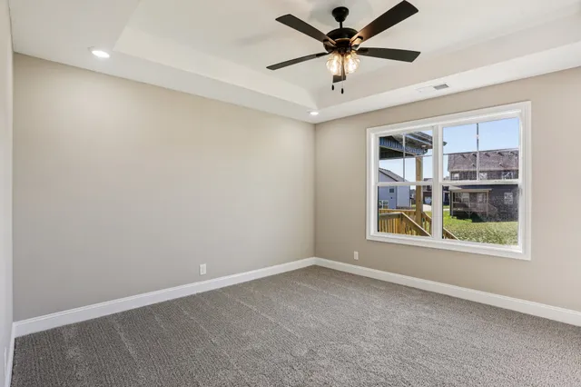 a view of a livingroom with a ceiling fan window and a ceiling fan