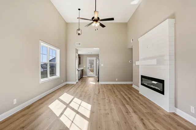 a view of an empty room with a window and a ceiling fan