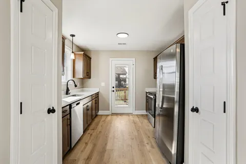 a kitchen with stainless steel appliances granite countertop a refrigerator and a stove