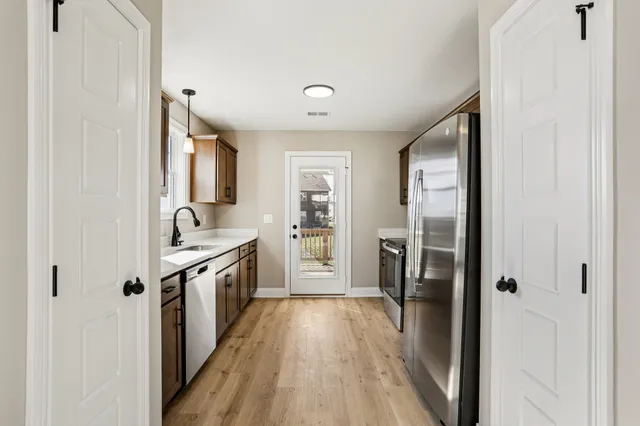 a kitchen with stainless steel appliances granite countertop a refrigerator and a stove