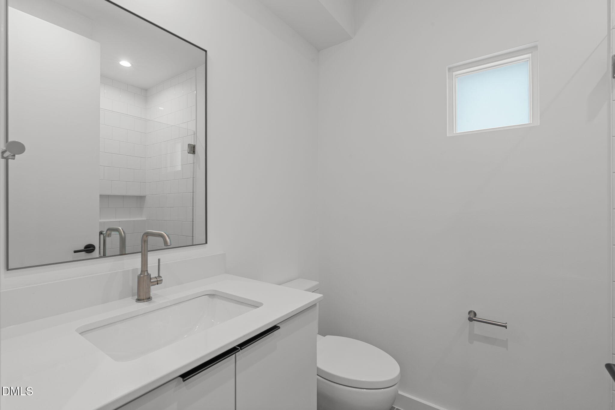 501 South Bloodworth Street, Unit 105 Raleigh, NC 27601 - Photo 31 of 59 a bathroom with a sink a toilet and a mirror