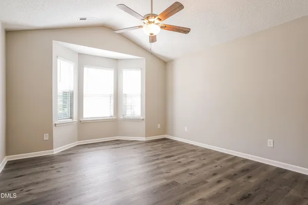 a view of an empty room with wooden floor