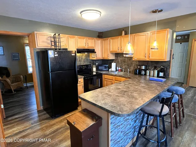 a kitchen with stainless steel appliances granite countertop a refrigerator a stove and a sink