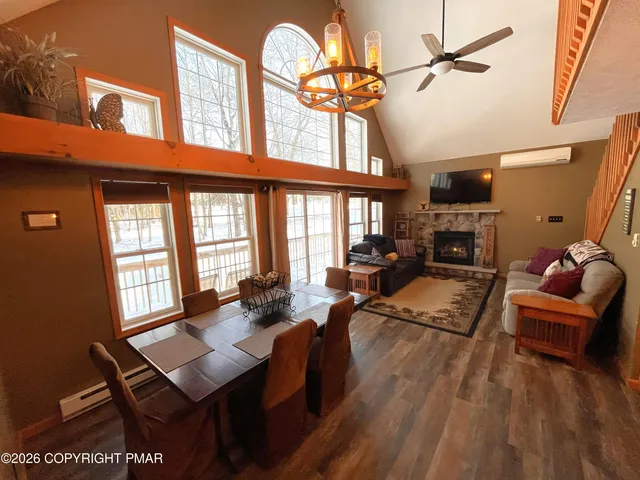 a living room with furniture a fireplace and large windows
