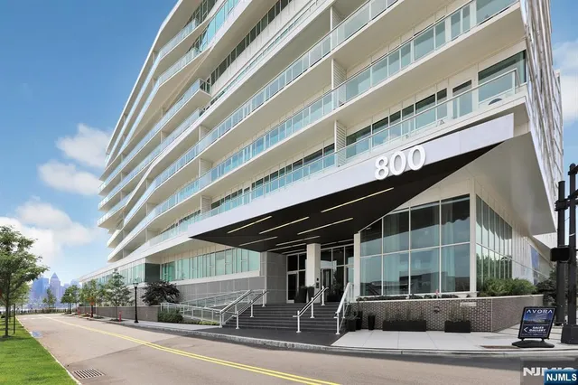 a front view of a building with streets and trees