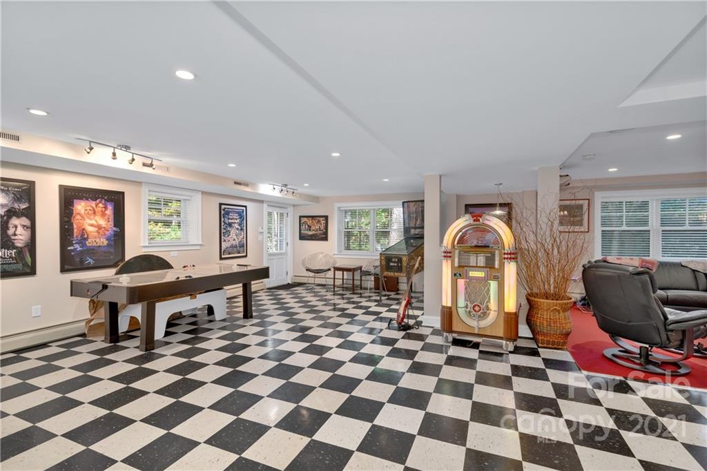 9 Forest Road Biltmore Forest, NC 28803 - Photo 31 of 36 a living room with a black white checkered floor with a gaming machine and dining chair