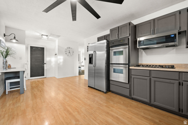 9750 Indian Ridge Drive Sandy, UT 84092 - Photo 17 of 40 Kitchen with stainless steel appliances, gray cabinetry, light wood-style flooring, and ceiling fan