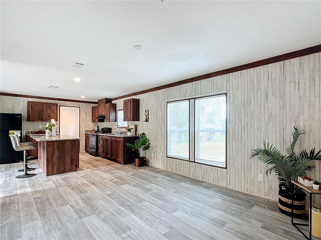 8551 Northwest 125 Street Chiefland, FL 32626 - Photo 11 of 35 a large open kitchen with stainless steel appliances kitchen island a large counter top and a wooden floors