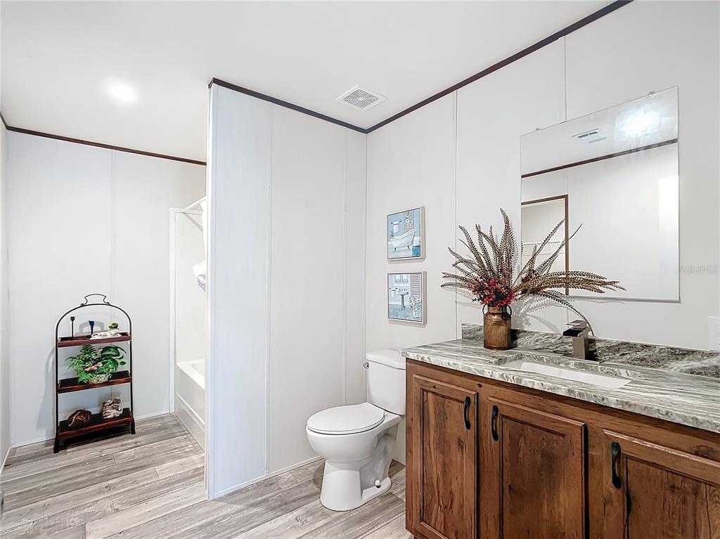 8551 Northwest 125 Street Chiefland, FL 32626 - Photo 27 of 35 a bathroom with a granite countertop sink a toilet and a mirror