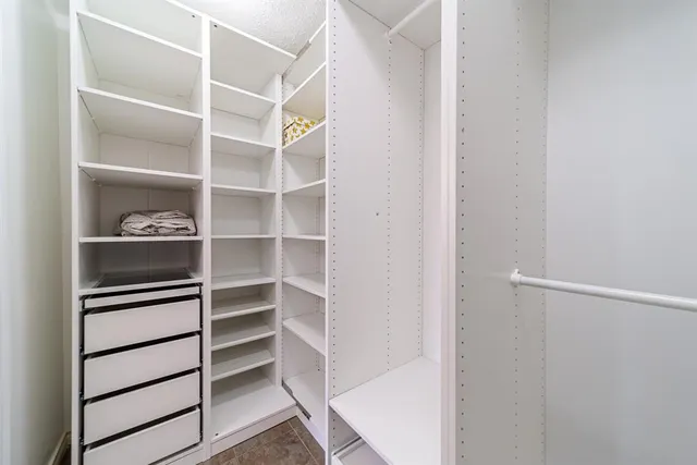 a view of walk in closet with empty racks