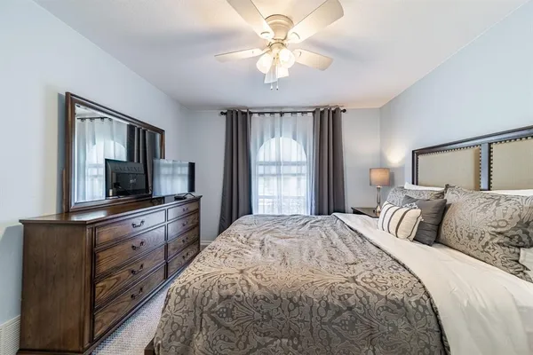 a bedroom with a large bed and a flat tv screen on dresser