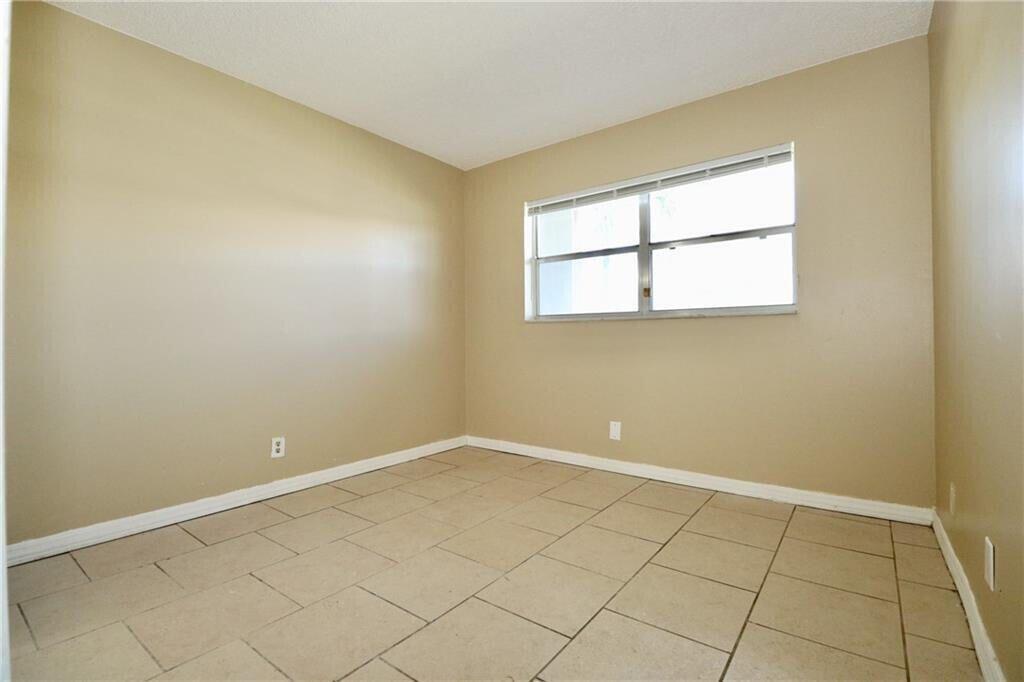 9915 Sandalfoot Boulevard, Unit 408 Boca Raton, FL 33428 - Photo 11 of 19 an empty room with a window