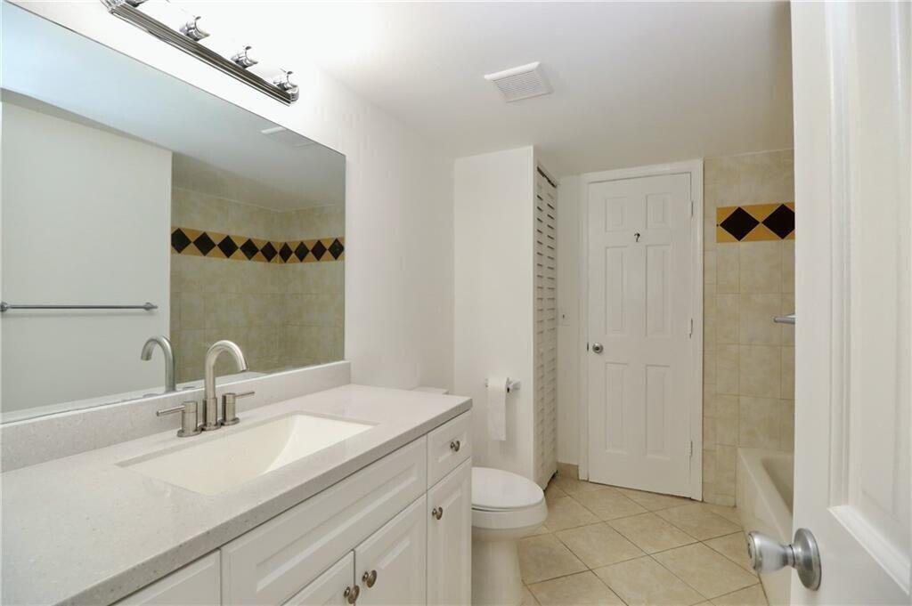 9915 Sandalfoot Boulevard, Unit 408 Boca Raton, FL 33428 - Photo 14 of 19 a bathroom with a sink and a mirror
