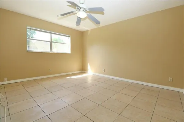 an empty room with a ceiling fan and a shower