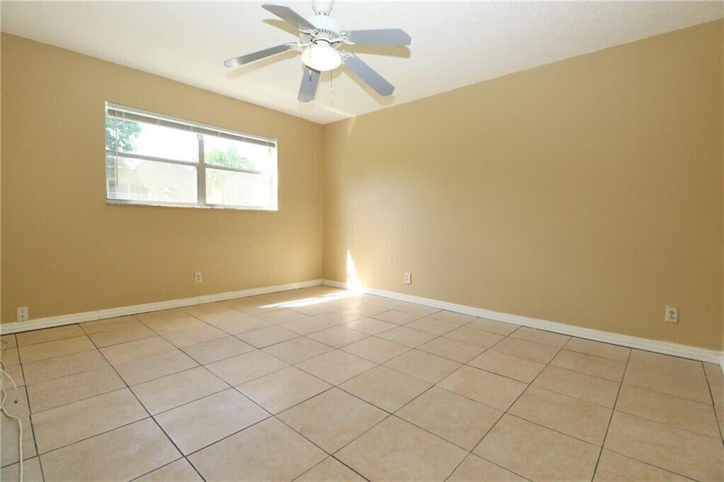 9915 Sandalfoot Boulevard, Unit 408 Boca Raton, FL 33428 - Photo 16 of 19 an empty room with windows and fan