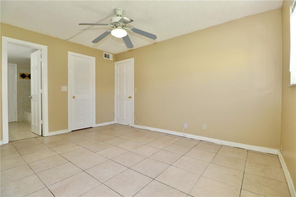 9915 Sandalfoot Boulevard, Unit 408 Boca Raton, FL 33428 - Photo 17 of 19 an empty room with a ceiling fan and a shower