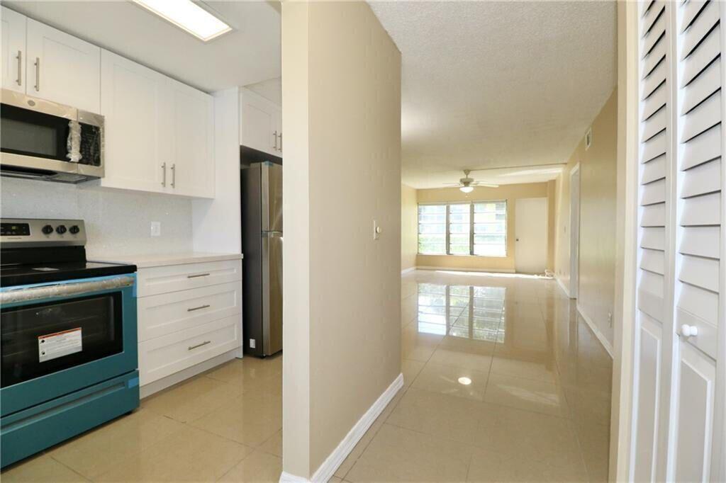 9915 Sandalfoot Boulevard, Unit 408 Boca Raton, FL 33428 - Photo 5 of 19 a view of a kitchen with electric appliances