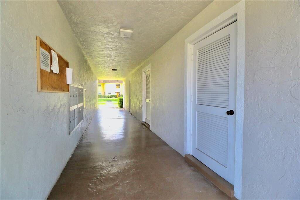 9915 Sandalfoot Boulevard, Unit 408 Boca Raton, FL 33428 - Photo 6 of 19 a view of a hallway with wooden floor and staircase
