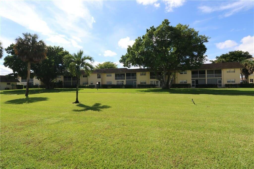 9915 Sandalfoot Boulevard, Unit 408 Boca Raton, FL 33428 - Photo 8 of 19 a swimming pool with lots of tress in front of it