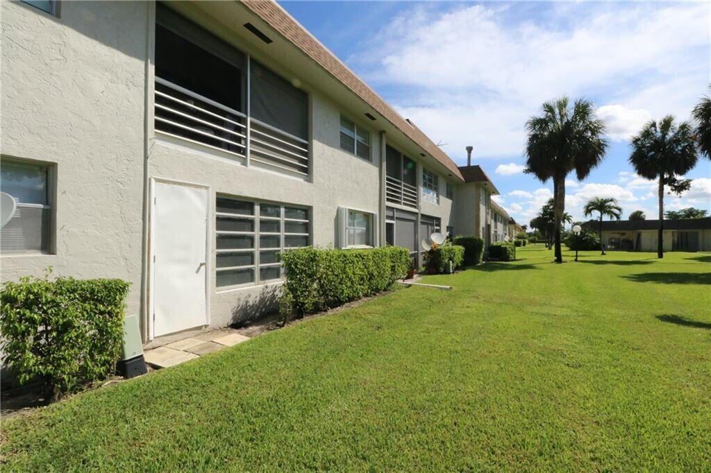 9915 Sandalfoot Boulevard, Unit 408 Boca Raton, FL 33428 - Photo 9 of 19 a front view of a house with a yard