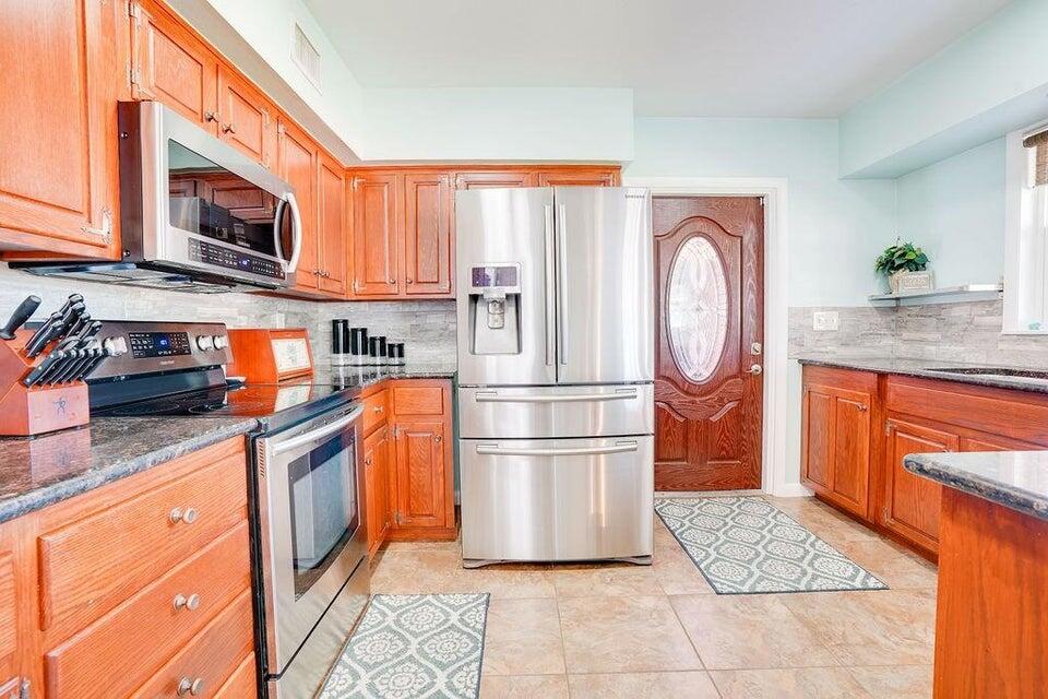 7600 Immokolee Road Fort Pierce, FL 34951 - Photo 16 of 32 a kitchen with stainless steel appliances granite countertop a refrigerator a stove top oven and sink