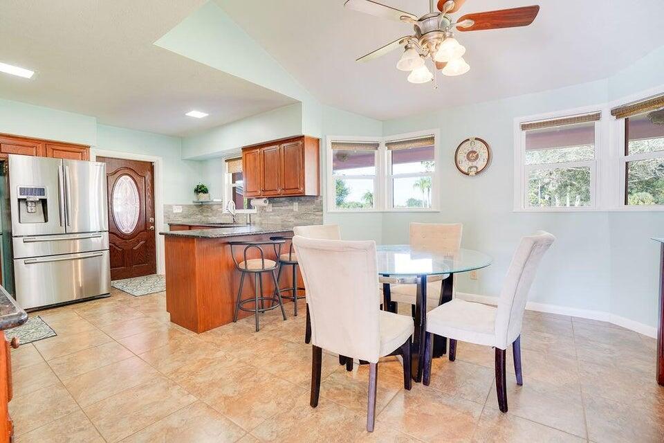 7600 Immokolee Road Fort Pierce, FL 34951 - Photo 17 of 32 a kitchen with stainless steel appliances a dining table chairs and window