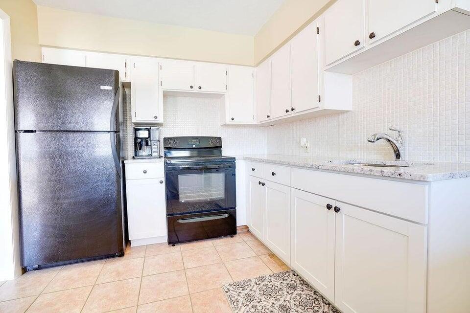7600 Immokolee Road Fort Pierce, FL 34951 - Photo 27 of 32 a kitchen with granite countertop a refrigerator and a stove