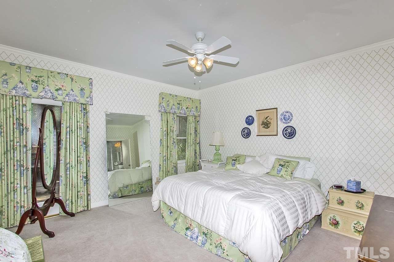 7619 Trowbridge Court Raleigh, NC 27613 - Photo 13 of 25 a bedroom with a bed and a chandelier