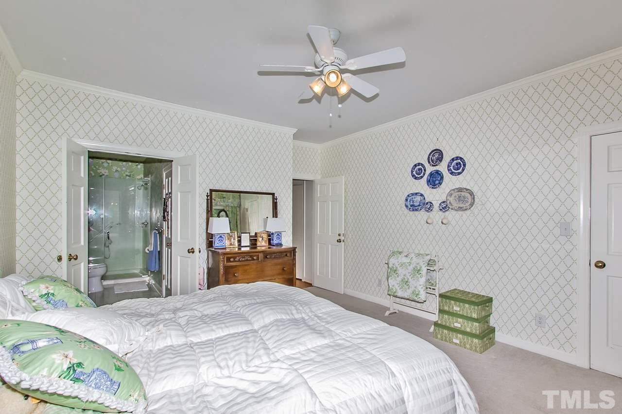 7619 Trowbridge Court Raleigh, NC 27613 - Photo 14 of 25 a bedroom with a bed and a chandelier