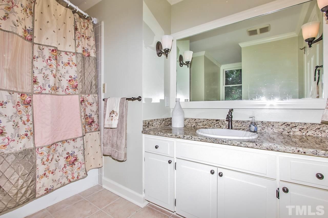 7619 Trowbridge Court Raleigh, NC 27613 - Photo 19 of 25 a bathroom with a granite countertop sink and a mirror