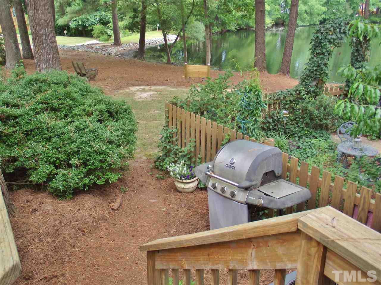 7619 Trowbridge Court Raleigh, NC 27613 - Photo 24 of 25 a view of a backyard with table and chairs potted plants and large tree