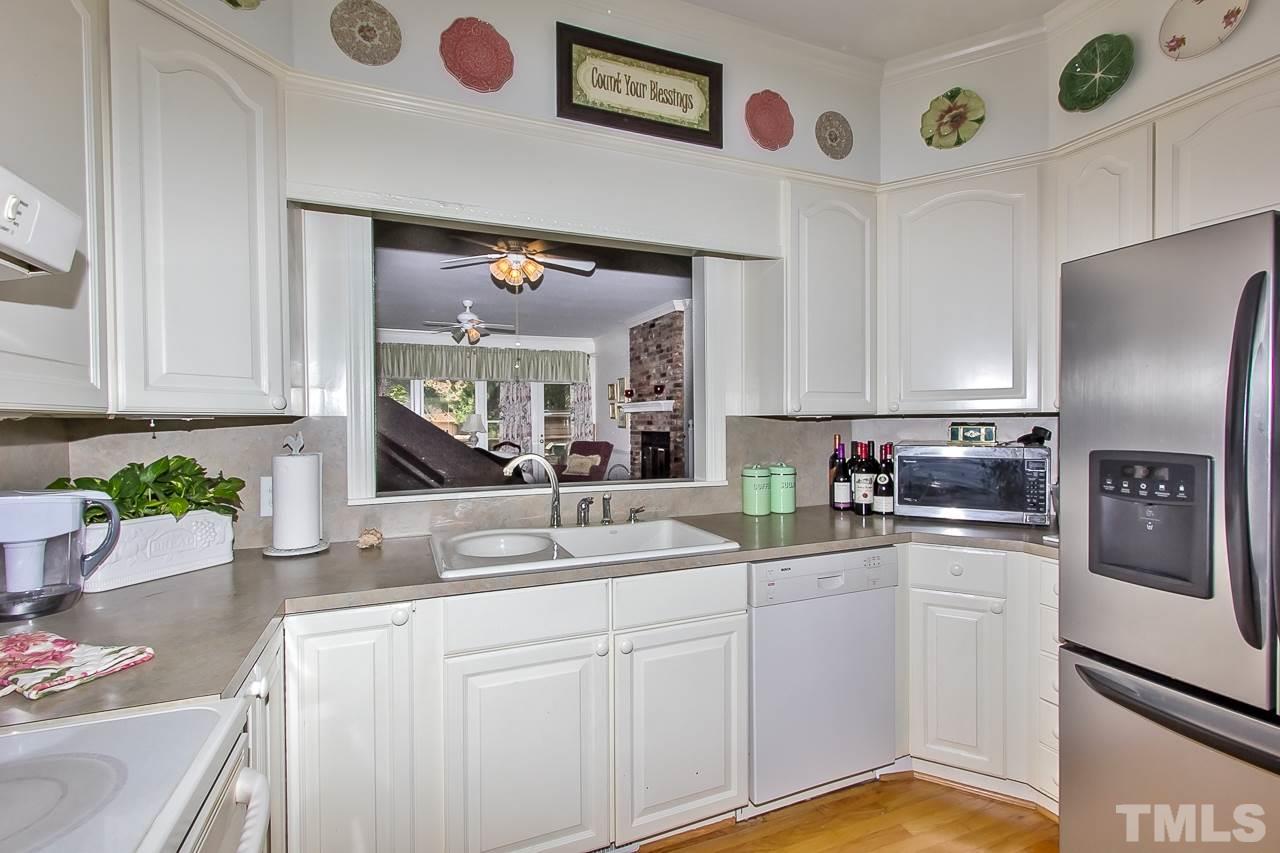 7619 Trowbridge Court Raleigh, NC 27613 - Photo 8 of 25 a kitchen with stainless steel appliances granite countertop a refrigerator a sink a stove and white cabinets