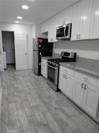 a kitchen with stainless steel appliances granite countertop a stove a sink and a refrigerator