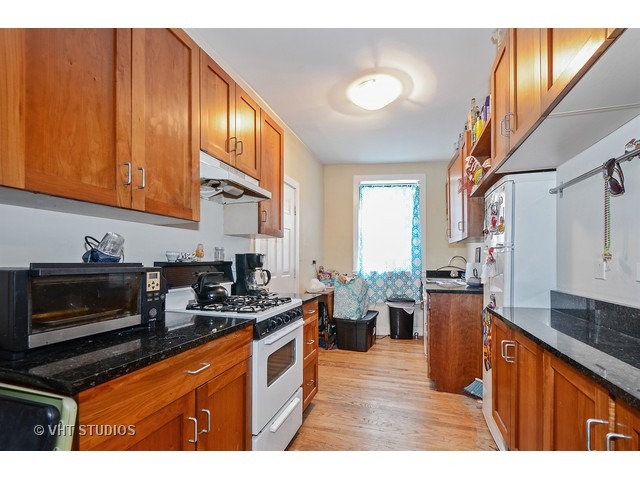 7031.5 North Sheridan Road, Unit 1N Chicago, IL 60626 - Photo 3 of 8 a kitchen with stainless steel appliances granite countertop a stove a sink dishwasher and a microwave