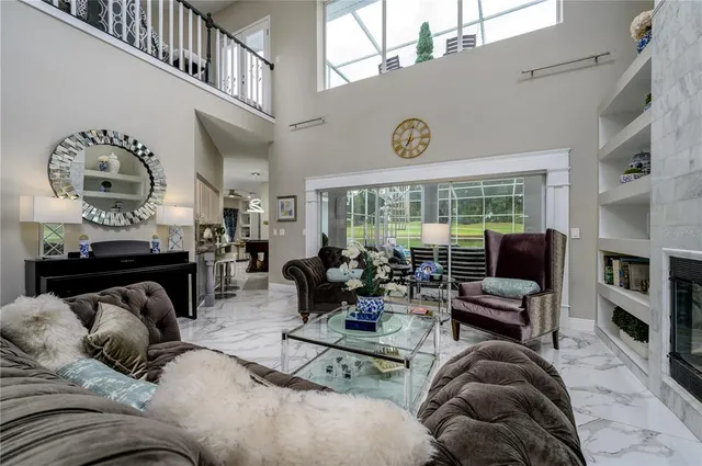 a living room with furniture a fireplace and a floor to ceiling window