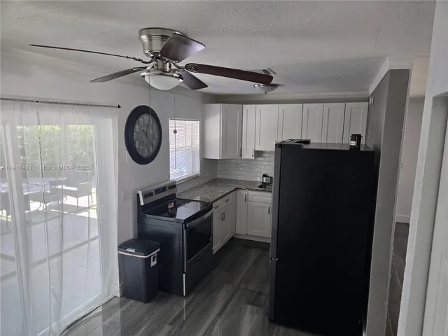 a kitchen with a refrigerator and a clock