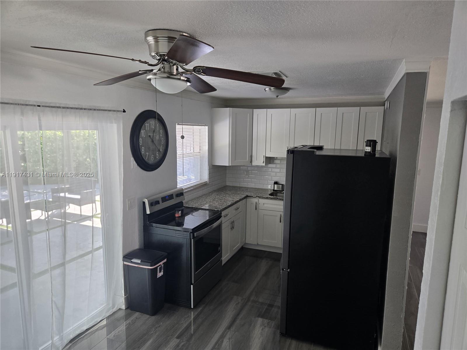 2190 Northeast 1st Lane Boynton Beach, FL 33435 - Photo 11 of 14 a kitchen with a refrigerator and a clock