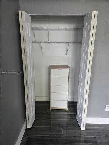 an empty room with wooden floor and closet