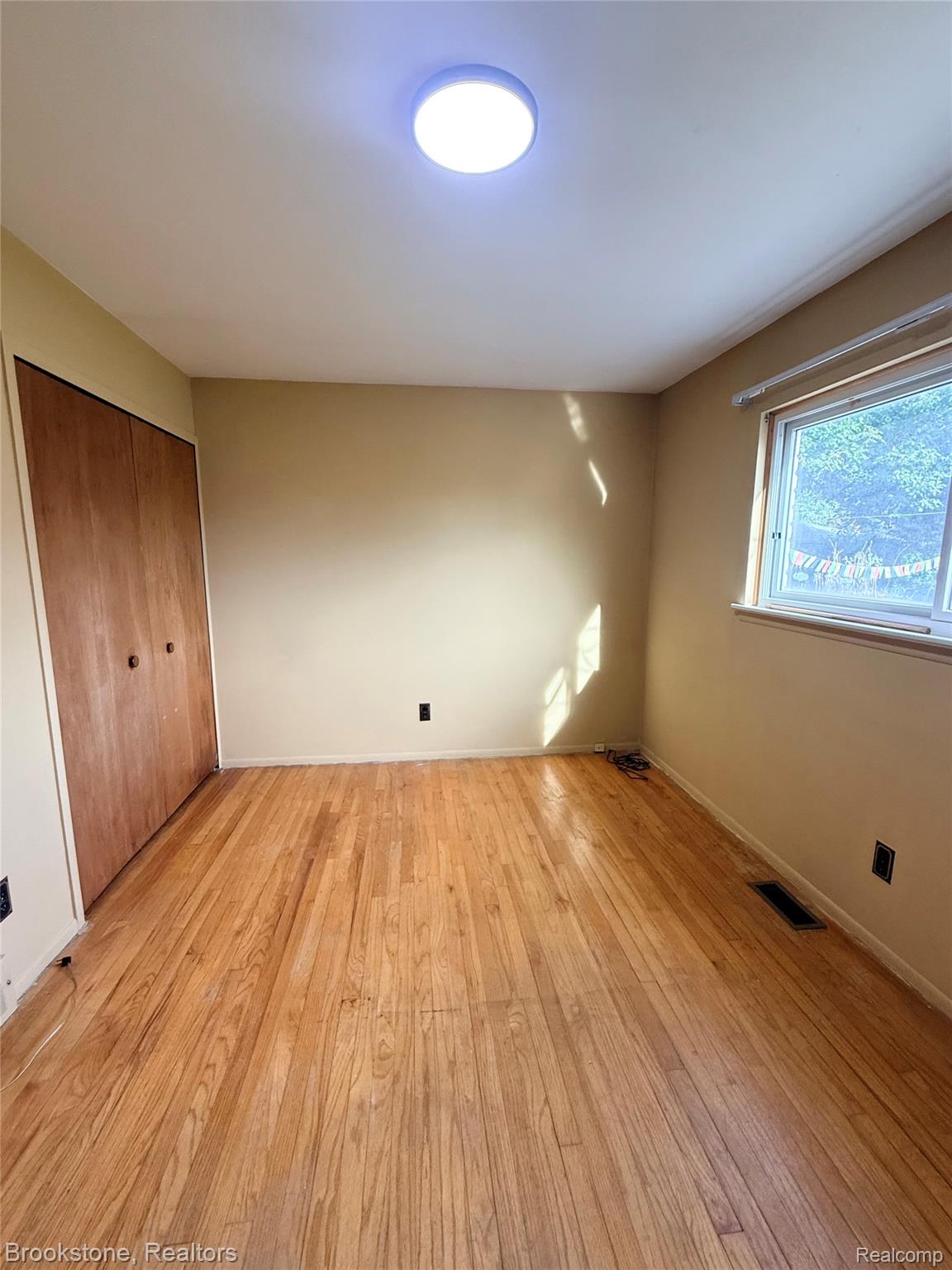 14144 Martin Road Warren, MI 48088 - Photo 6 of 10 Wood-finish flooring with a built-in closet featuring bi-fold doors