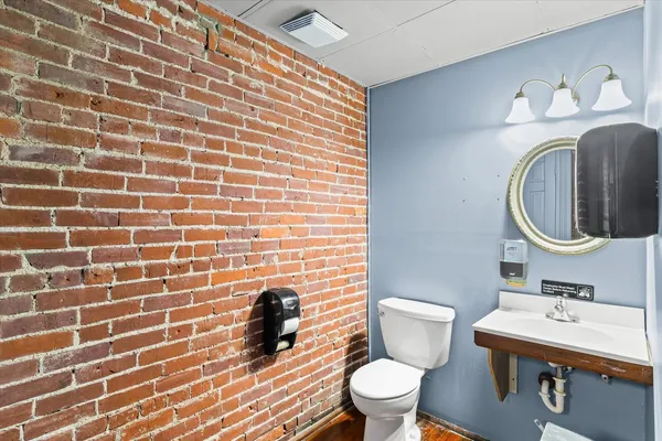 a bathroom with a granite countertop sink toilet and a mirror