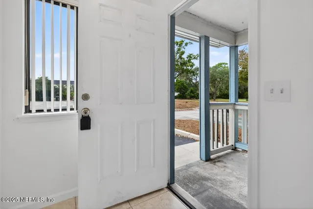 an entryway with wooden floor and windows