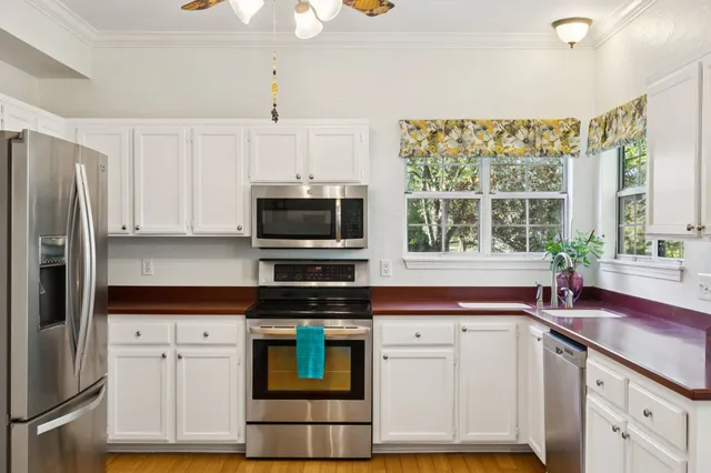 a kitchen with white cabinets and appliances