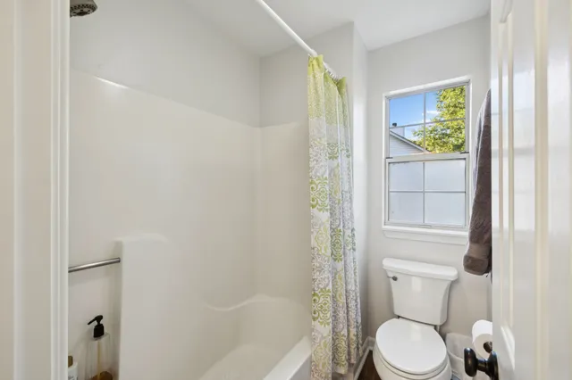 a white toilet sitting next to a bath tub shower