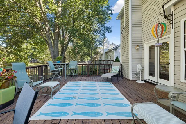 a balcony with wooden floor table and chairs