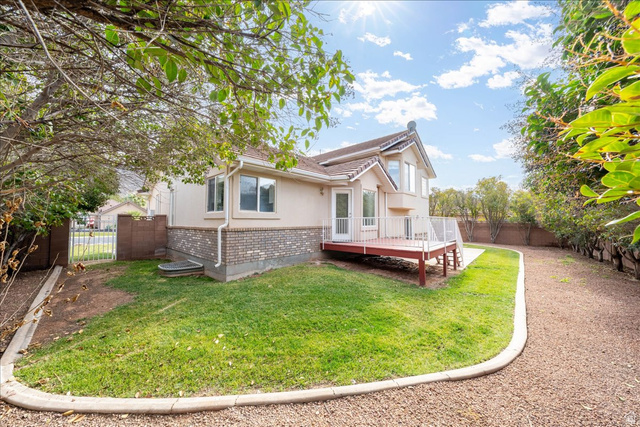 7 Reflection Way St. George, UT 84770 - Photo 53 of 54 Rear view of house with a deck, a fenced backyard, brick siding, and stucco siding